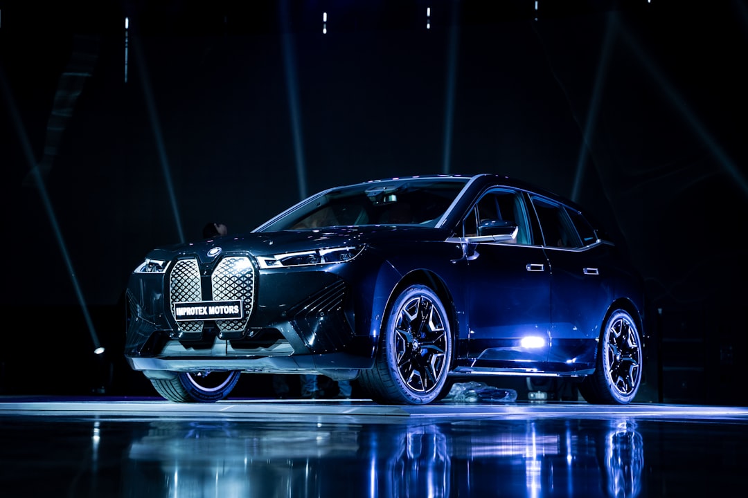 BMW i5 Touring électrique exposée dans une salle d'exposition sombre