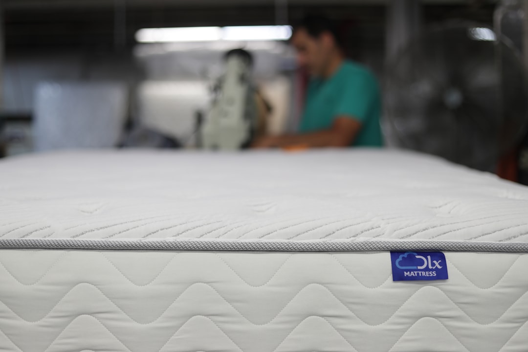 Ouvrier contrôlant la taille d'un matelas dans un entrepôt de production